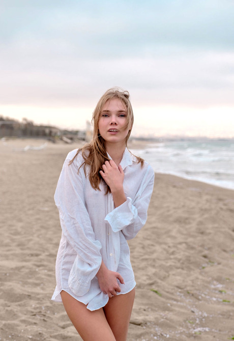 Blonde babe Luise strips shirt on beach before spreading legs on sand - 1 of 12