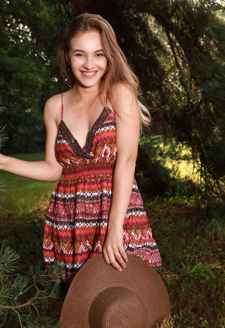 Young happy model Terezza playfully stripping naked outdoors